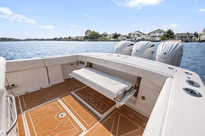 Slide: The Image of 2024 Regulator 34 boat with spacious deck, triple engines, and scenic waterfront view. - 11