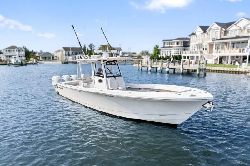 Slide: The Image of 2024 Regulator 34 boat cruising in a scenic waterfront neighborhood. - 3