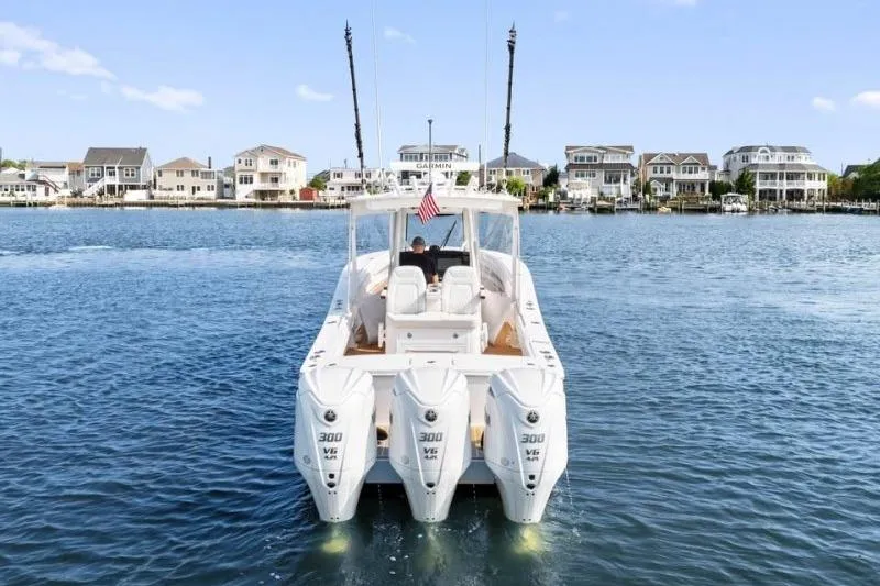 Slide: The Image of 2024 Regulator 34 boat with triple 300 V6 engines on a scenic waterfront. - 5