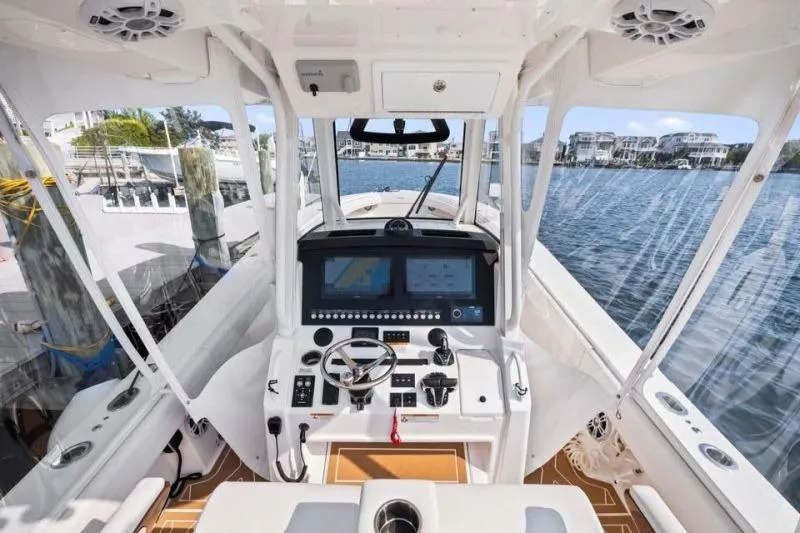 Slide: The Image of 2024 Regulator 34 boat cockpit with advanced navigation system and waterfront view. - 6