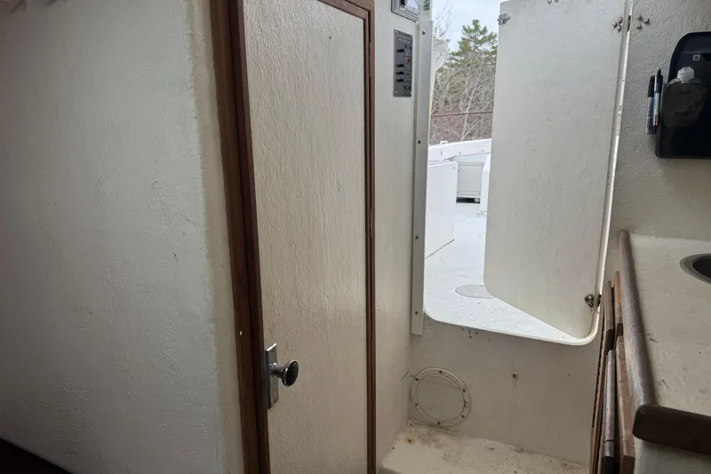 Slide: The Image of Interior view of a 2001 Eastern Lobsterman 27 boat, featuring a cabin door and sink. - 10