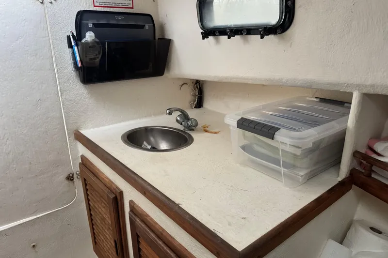 Slide: The Image of Compact boat kitchenette with sink, storage cabinets, and plastic container, Eastern Lobsterman 27, 2001 model. - 12