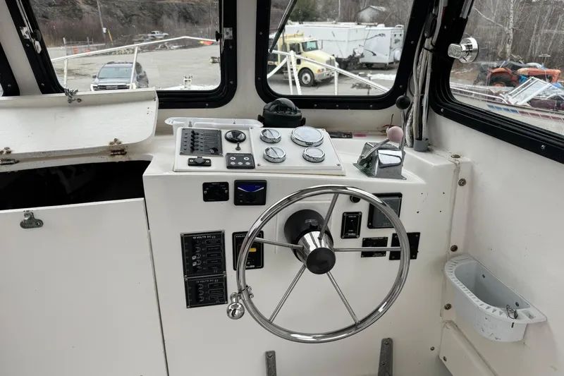Slide: The Image of Interior view of a 2001 Eastern Lobsterman 27 boat cockpit with steering wheel and controls. - 13