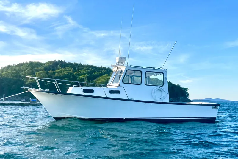 Slide: The Image of 2001 Eastern 27 Lobster Fisherman boat on water, scenic background, clear blue sky. - 20