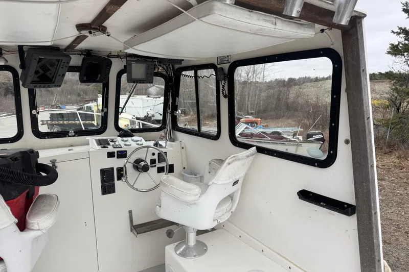 Slide: The Image of Interior of a 2001 Eastern Lobsterman 27 boat with steering wheel and controls. - 5