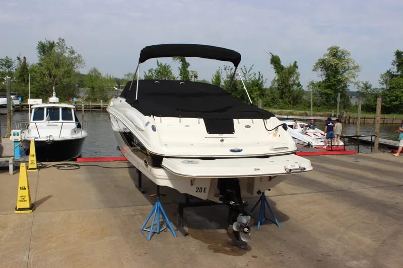 The Image of 2005 Chaparral 265 SSi boat on stands at a marina, covered and ready for maintenance. - 1