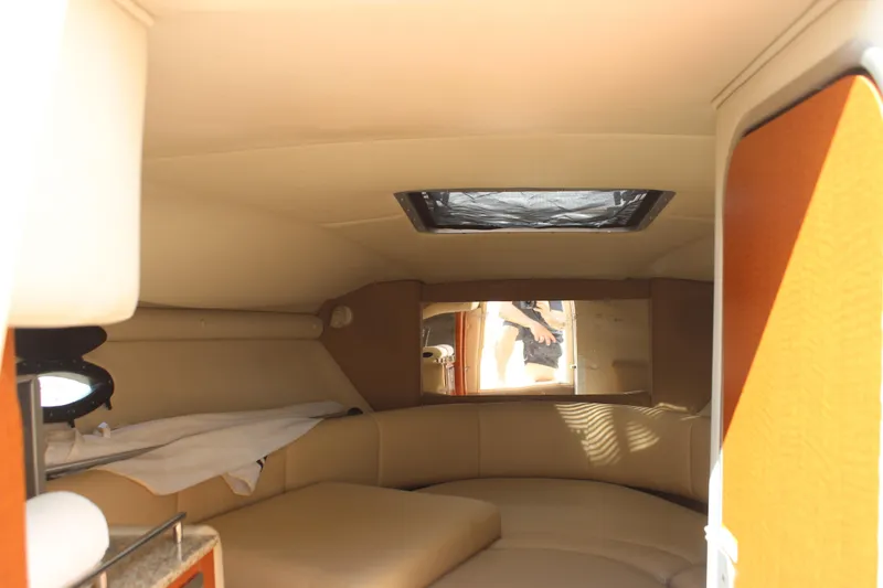 Slide: The Image of Interior cabin of 2005 Chaparral 265 SSi boat, featuring cozy seating and natural light. - 21