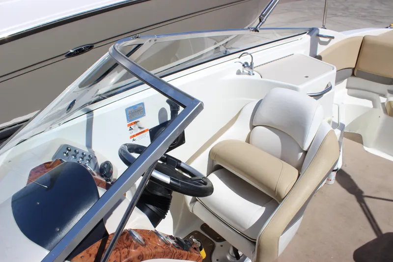 Slide: The Image of 2005 Larson LXi 268 boat interior with steering wheel and seating area. - 13