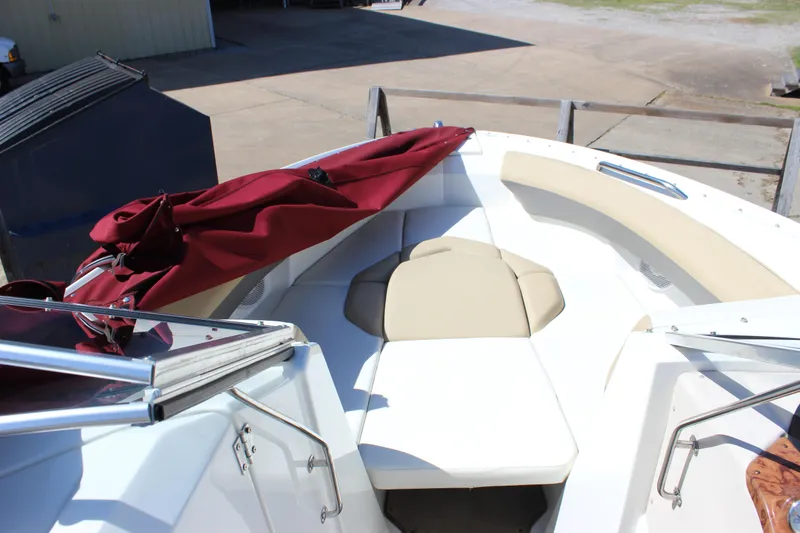 Slide: The Image of 2005 Larson LXi 268 boat interior with beige seating and red cover. - 14
