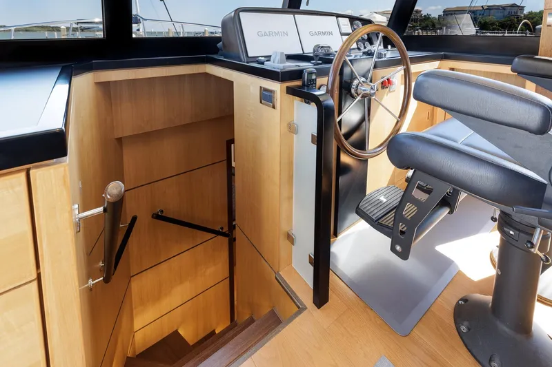 Slide: The Image of 2023 North Pacific 49 Euro yacht helm with wooden steering wheel and staircase. - 13