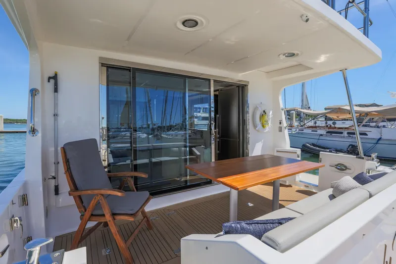 Slide: The Image of Luxurious 2023 North Pacific 49 Euro yacht deck with seating and table, docked at marina. - 27