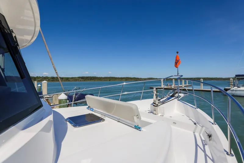Slide: The Image of 2023 North Pacific 49 Euro yacht docked, showcasing sleek deck design and scenic waterfront view. - 29