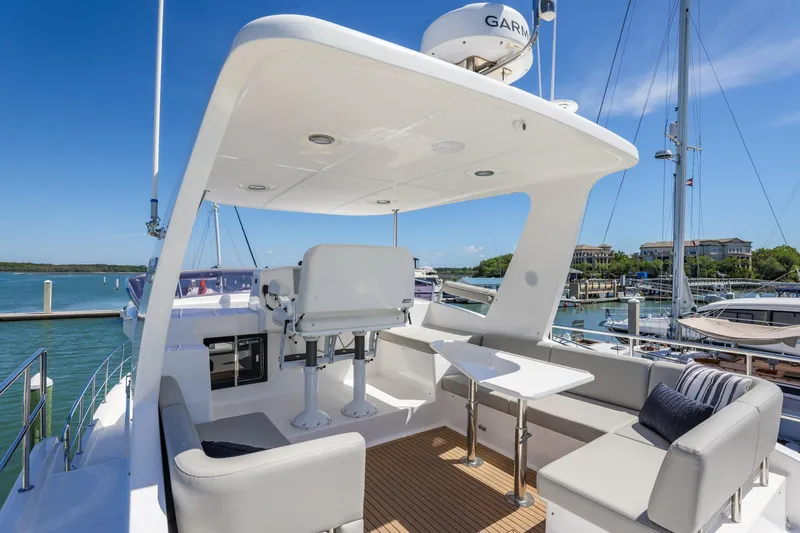 Slide: The Image of Luxurious 2023 North Pacific 49 Euro yacht deck with seating and table, docked at marina. - 33