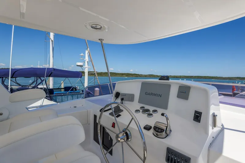Slide: The Image of Helm of 2023 North Pacific 49 Euro yacht with Garmin navigation, overlooking serene waters. - 36