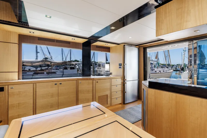 Slide: The Image of Luxurious interior of 2023 North Pacific 49 Euro yacht with modern wood finishes and marina view. - 7