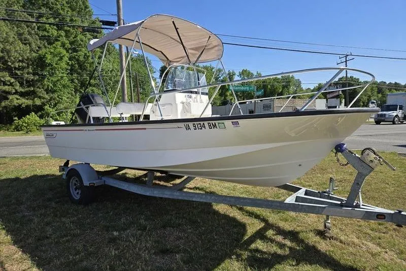Slide: The Image of 2007 Boston Whaler 190 Montauk boat on trailer with canopy, parked outdoors. - 10