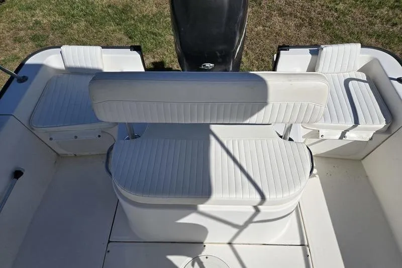 Slide: The Image of 2007 Boston Whaler 190 Montauk boat interior with white cushioned seating. - 16