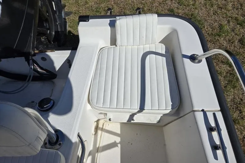 Slide: The Image of 2007 Boston Whaler 190 Montauk boat interior with white cushioned seating. - 9