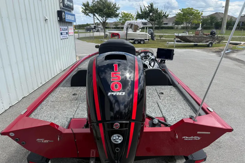 Slide: The Image of Red 2023 Pro Team 195 boat with 150 Pro engine, parked outdoors. - 6