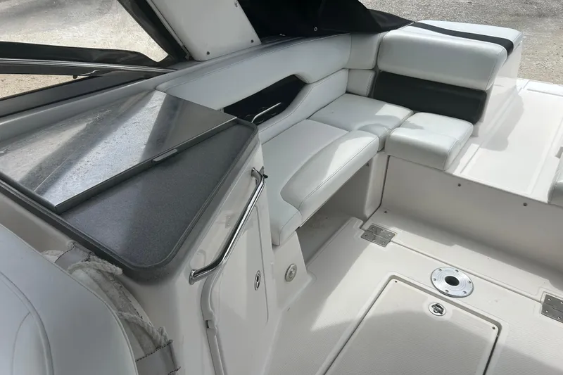 Slide: The Image of Interior of a 2008 Regal 2700 Bowrider boat with white seating and storage area. - 19