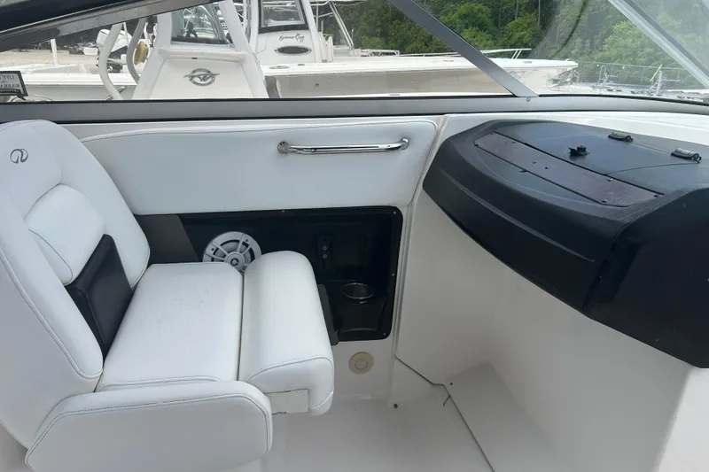 Slide: The Image of Interior of a 2008 Regal 2700 Bowrider boat, featuring white seating and dashboard. - 8