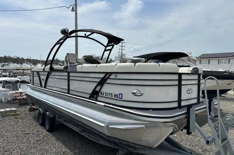 Slide: The Image of 2024 Veranda VP Tower 25 RCT pontoon boat on trailer, dockside view. - 3