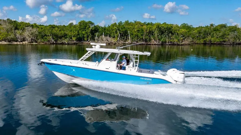 Slide: The Image of 2019 Everglades 355 Center Console cruising on calm water, surrounded by trees. - 3