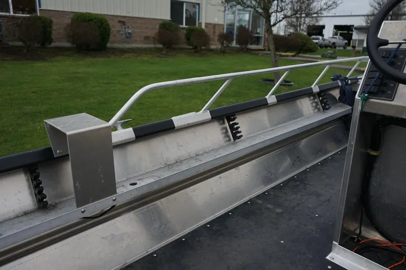 Slide: The Image of 2021 Wooldridge 16 Alaskan LT boat interior with metal railing and steering console. - 10