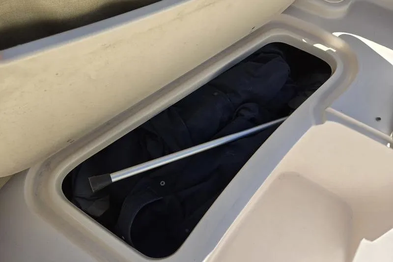 Slide: The Image of Storage compartment in a 2007 Grady-White Tournament 205 boat, containing a metal rod. - 13