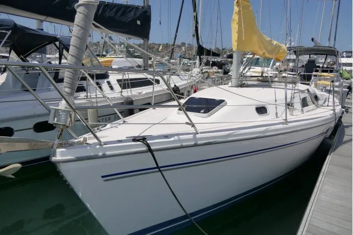 The Image of 2001 Catalina 310 sailboat docked at marina, featuring sleek white hull and yellow sail cover. - 0