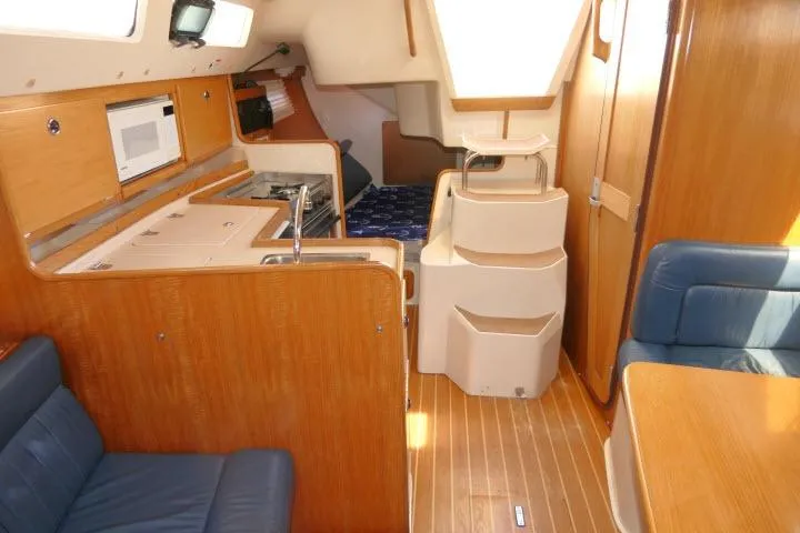 Slide: The Image of Interior of a 2001 Catalina 310 sailboat with wood finishes and compact kitchen. - 11