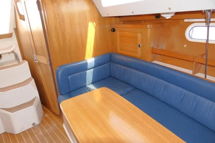 Slide: The Image of Interior of a 2001 Catalina 310 sailboat with blue seating and wooden table. - 12