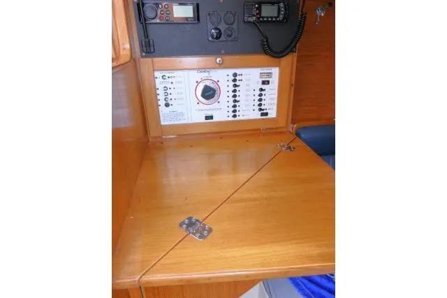 Slide: The Image of Navigation panel inside a 2001 Catalina 310 sailboat, featuring control switches and radio equipment. - 13