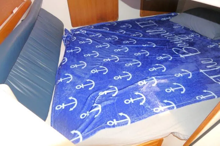 Slide: The Image of Cozy cabin bed in 2001 Catalina 310 sailboat with nautical-themed blue blanket. - 14