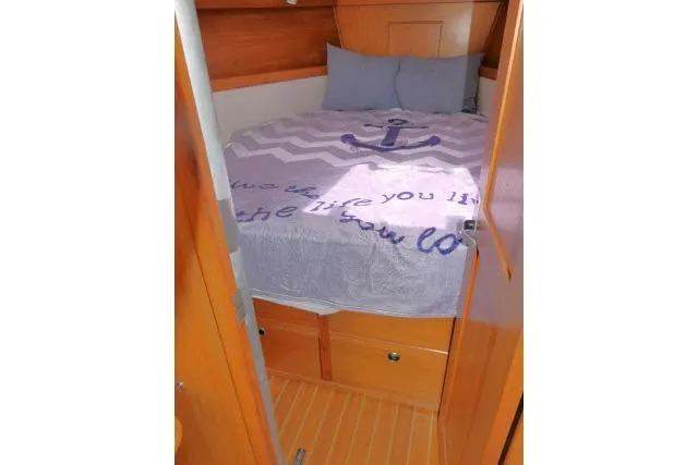 Slide: The Image of Cozy cabin interior of 2001 Catalina 310 sailboat with nautical-themed bedding. - 16