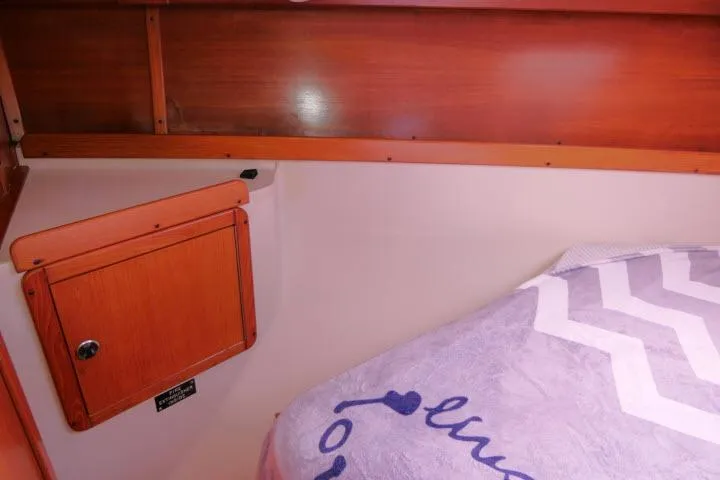 Slide: The Image of Interior cabin of 2001 Catalina 310 sailboat with wooden paneling and cozy bedding. - 18