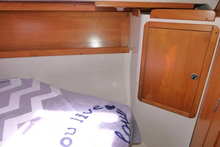 Slide: The Image of Cozy cabin interior of 2001 Catalina 310 sailboat with wooden storage and patterned bedding. - 21