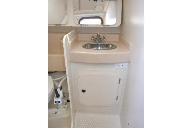 Slide: The Image of 2001 Catalina 310 yacht bathroom with sink, mirror, and storage cabinet. - 23