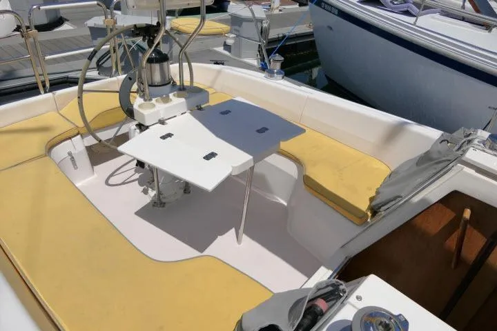 Slide: The Image of Cockpit of a 2001 Catalina 310 sailboat with yellow cushions and a central table. - 29