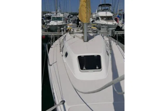 Slide: The Image of 2001 Catalina 310 sailboat docked in a marina, surrounded by other boats. - 37