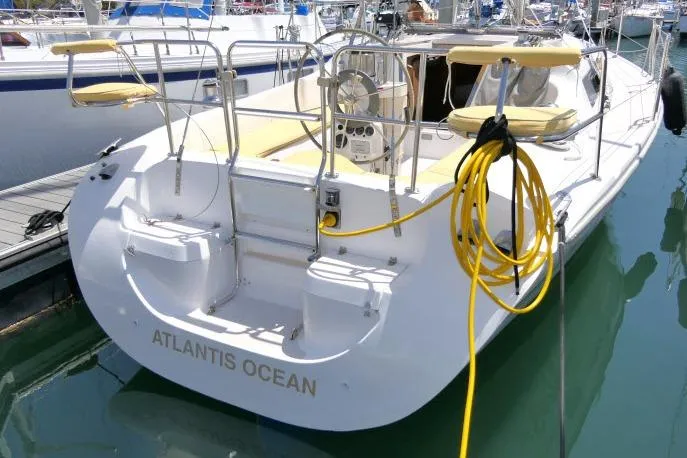 Slide: The Image of 2001 Catalina 310 sailboat docked, featuring spacious cockpit and yellow seating. - 40