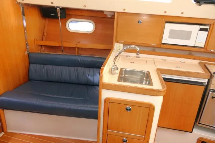 Slide: The Image of Interior of a 2001 Catalina 310 sailboat with kitchenette and seating area. - 5