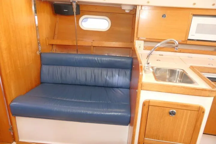 Slide: The Image of Interior of a 2001 Catalina 310 sailboat with blue seating and kitchenette. - 6