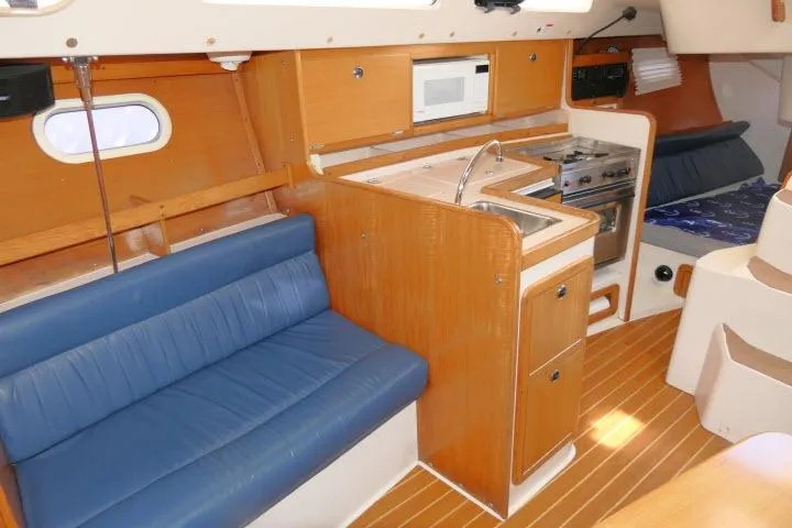 Slide: The Image of Interior of a 2001 Catalina 310 sailboat with kitchen and seating area. - 7