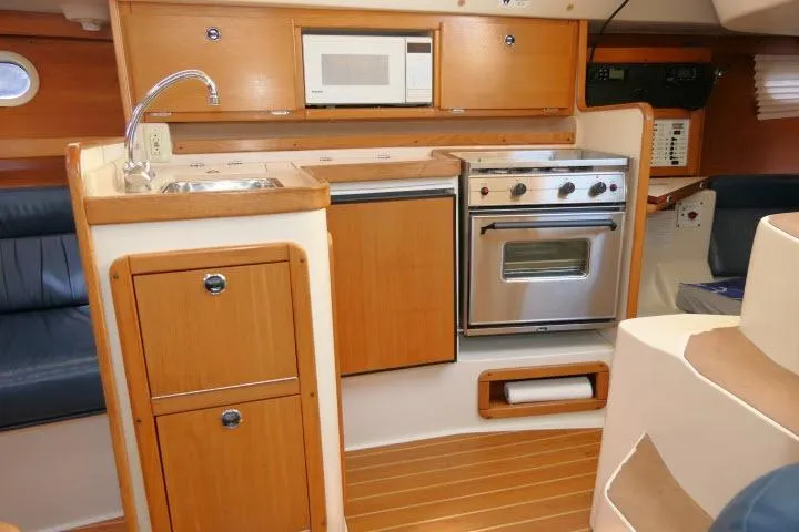 Slide: The Image of Interior of 2001 Catalina 310 yacht kitchen with wooden cabinetry and modern appliances. - 8