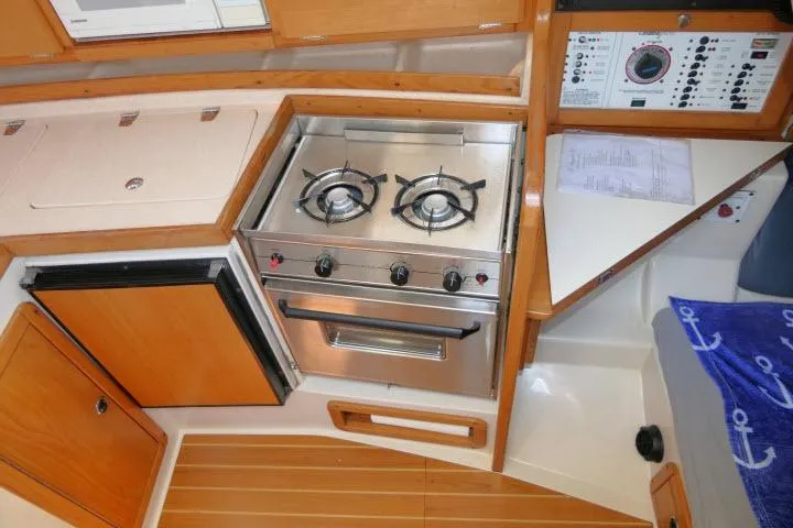 Slide: The Image of Compact kitchen area in a 2001 Catalina 310 sailboat with stove and control panel. - 9