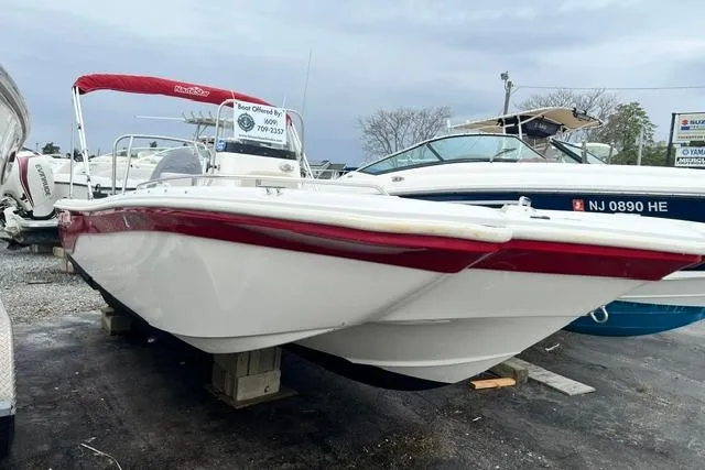 The Image of 2013 NauticStar 210 Coastal boat with red accents, displayed on a lot. - 0