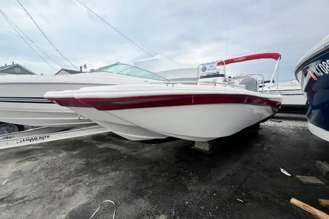 Slide: The Image of 2013 NauticStar 210 Coastal boat with red accents, parked on a trailer. - 2