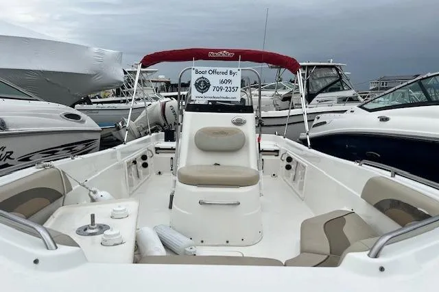 Slide: The Image of 2013 NauticStar 210 Coastal boat with seating, docked among other boats. - 6