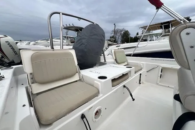 Slide: The Image of 2013 NauticStar 210 Coastal boat interior with beige seating and covered equipment. - 8